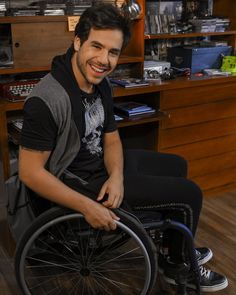 a man in a wheel chair smiling for the camera