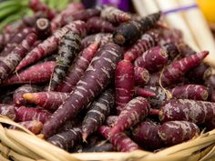 a basket filled with lots of purple carrots