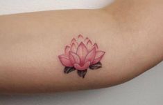 a small pink flower tattoo on the arm