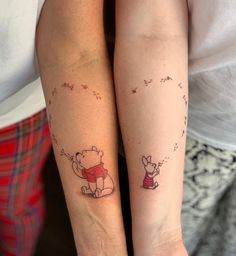 two people with matching tattoos on their arms, one has a bear and the other has a dog