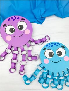 two paper cutouts of octopus and jellyfish on a white surface