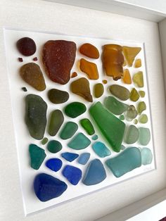 a white frame with sea glass in it