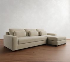 a couch sitting on top of a wooden floor next to a white wall and hardwood floors