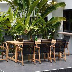 an outdoor table and chairs with potted plants in the background