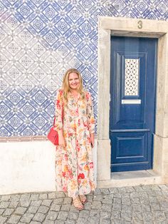 a woman standing in front of a blue door