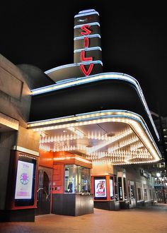 the marquee is lit up at night with bright lights on it's sides