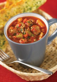 a bowl filled with meat and vegetables next to a slice of bread on a plate