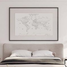 a bedroom with a bed and a framed world map on the wall above it,