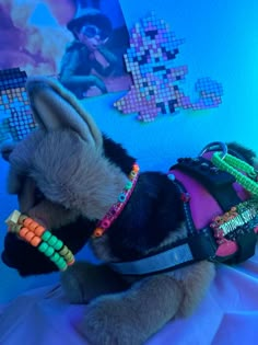 a stuffed animal with beads on it's neck and collar sitting on a bed