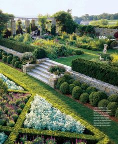 an aerial view of a formal garden with steps and flowers in the center, surrounded by greenery