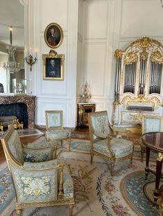 an ornately decorated living room with gold trimmings and blue upholstered chairs