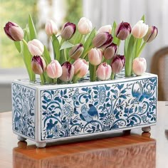 there are many tulips in the blue and white vase