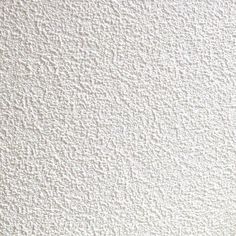 a vase filled with flowers sitting on top of a white table next to a wall