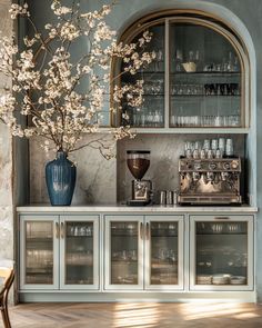 a vase filled with flowers sitting on top of a wooden table next to a bar