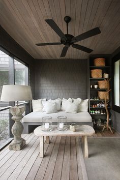 a living room filled with furniture and a ceiling fan in the middle of an open floor plan