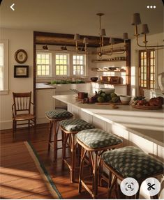 a kitchen filled with lots of counter top space and wooden stools next to an island