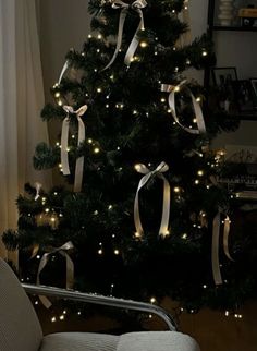 a decorated christmas tree with lights and ribbons