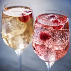 two wine glasses filled with liquid and strawberries