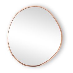 a round mirror on the wall with a copper frame and an oval mirror above it