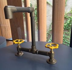 two pipes connected to each other on top of a blue table next to a window