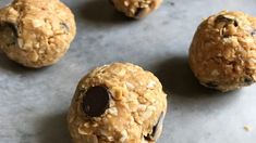 chocolate chip cookies and oatmeal balls sitting on a baking sheet, ready to be eaten