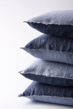 three blue pillows stacked on top of each other