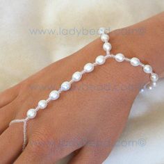 a woman's hand wearing a bracelet with pearls