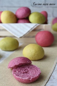 a pink and yellow doughnut sitting on top of a table next to lemons