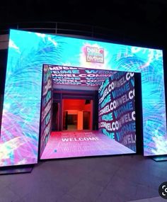 an entrance to a building that is lit up with colorful lights and words on it