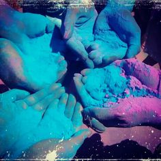 several hands are covered in blue and pink powder