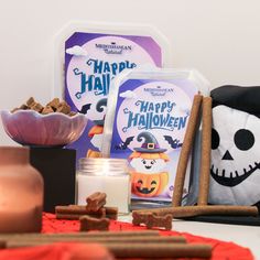 halloween treats are arranged on a table next to a candle and other items that include marshmallows