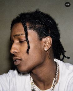 a young man with dreadlocks wearing a white shirt