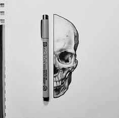 a pen is next to a drawing of a skull