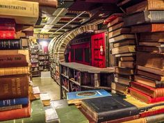 many books are stacked on top of each other in the library, with one red door at the end