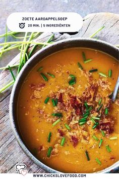 a bowl of soup with meat and green onions in it on top of a wooden table