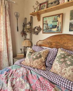 a bed sitting in a bedroom next to a window with curtains and pictures on the wall