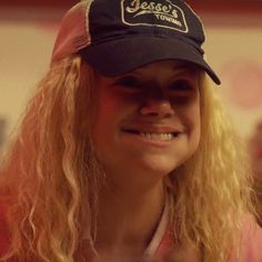 a woman with long blonde hair wearing a hat