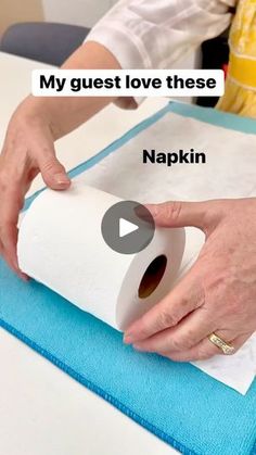 a person holding a roll of toilet paper on top of a blue mat with the words, my guest love these napkins