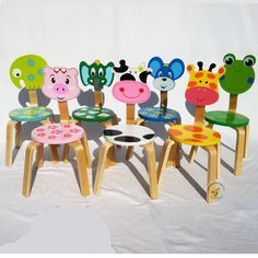 four wooden chairs with animal faces painted on the back and sides, all in different colors