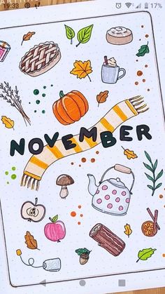 an open notebook with the words november written in black and white, surrounded by autumn items