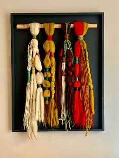 a group of different colored tassels hanging on a wall