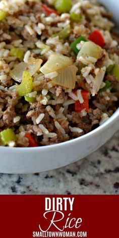 a white bowl filled with rice and vegetables on top of a marble counter next to a red sign that says dirty rice