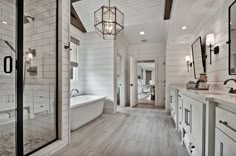 a large bathroom with white walls and wood flooring on the ceiling, along with a walk in shower