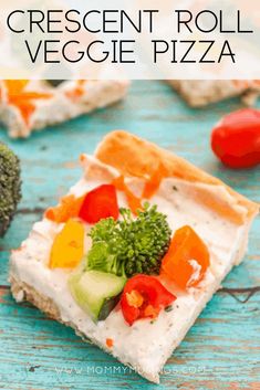 a piece of vegetable and cream cheese pizza on a blue wooden table with broccoli