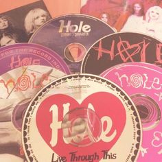 various cd's and cds with the words love through this hole written on them