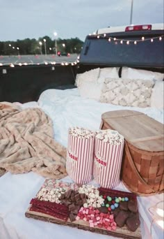 popcorn, chocolate and marshmallows on a bed with lights in the background