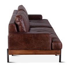 a brown leather couch sitting on top of a wooden frame