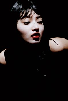 a woman with black hair and red lipstick