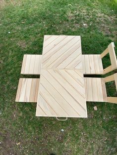 four pieces of wood laid out on the grass