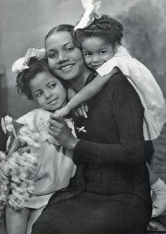 an old black and white photo shows a woman holding a child in her arms,